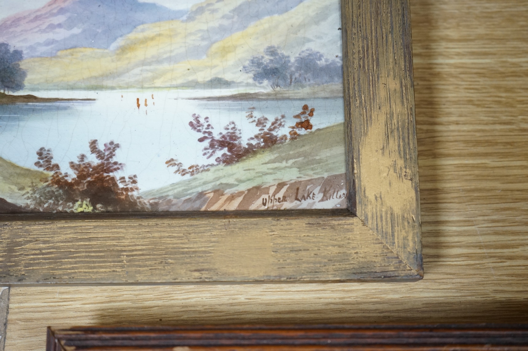 Four ceramic painted plaques depicting landscapes to include ‘Upper Lake Killard’, three framed, largest 36cm wide